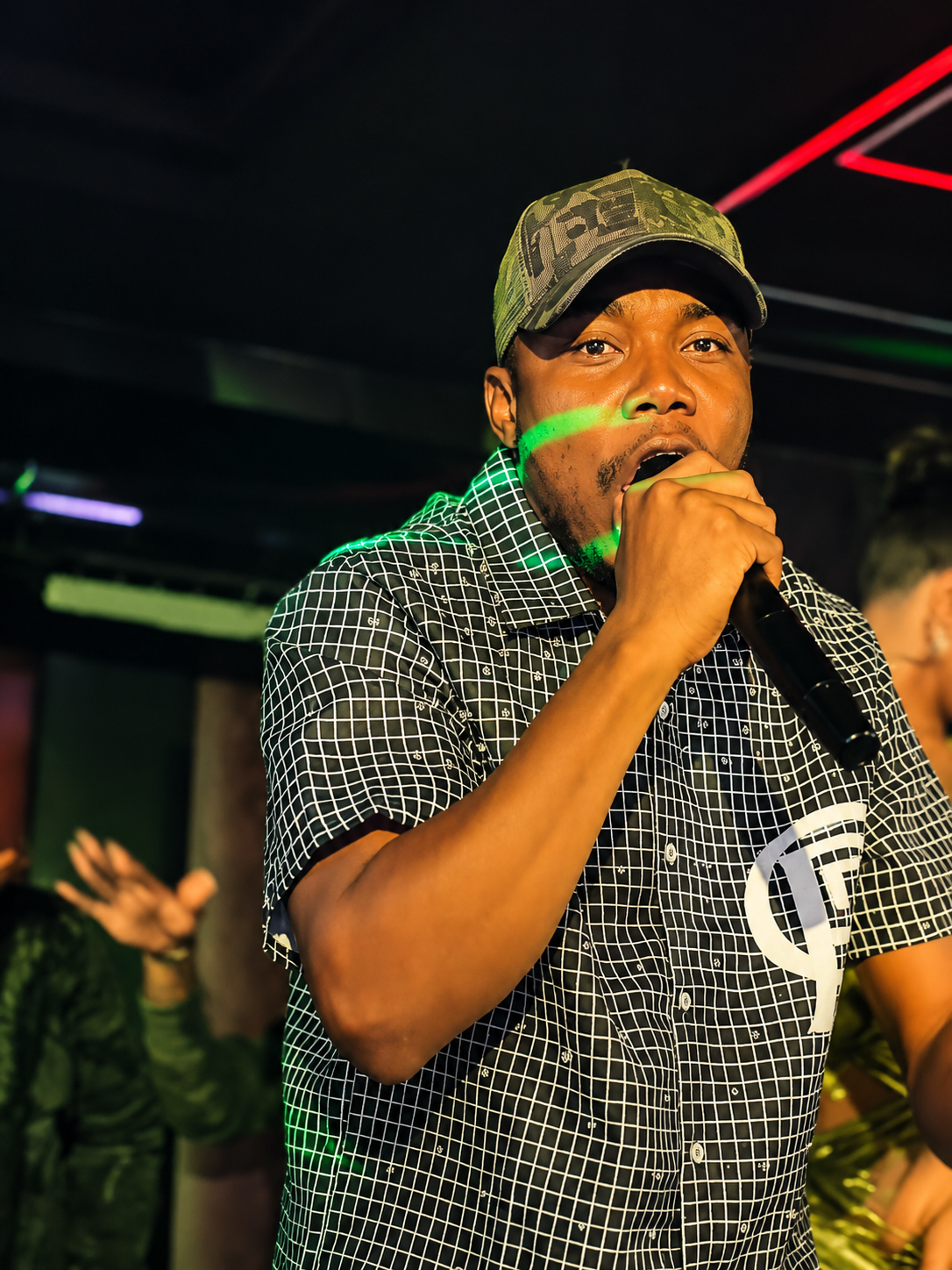 H3RITAGE in a camo hat — off-stage editorial portrait